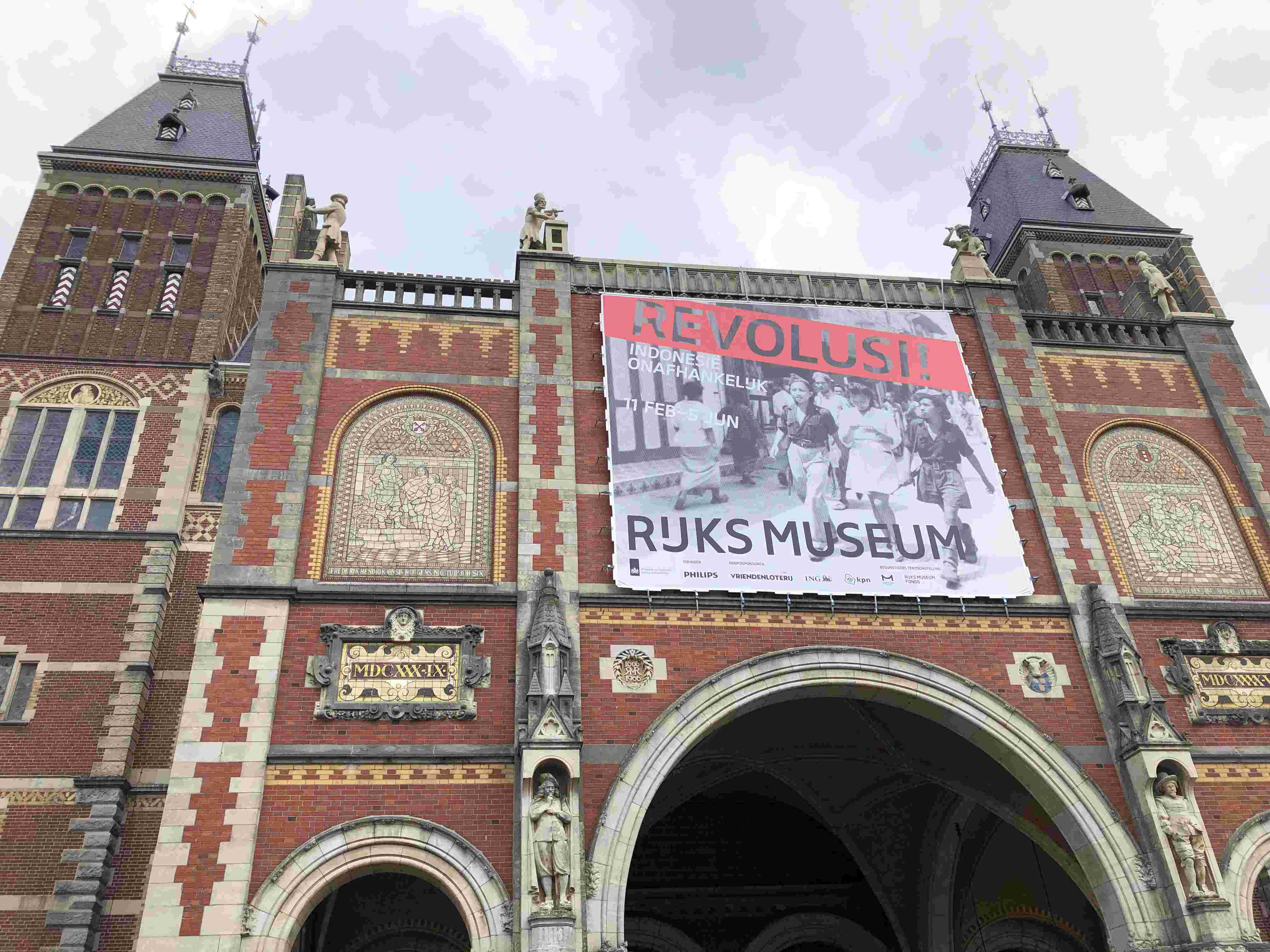Brick entrance to Rjiksmuseum n Amsterdam with arched doorways and two towers
